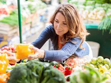 women choosing vegetables at supermarket