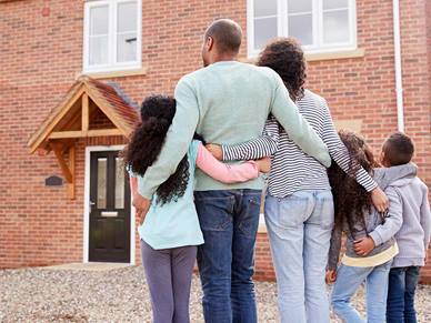 Decorate image of a family standing outside their new home